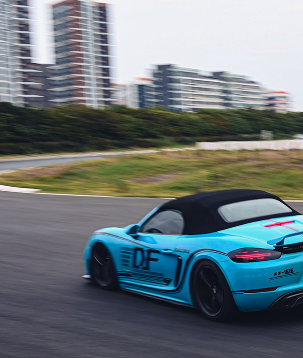 Blue Porsche convertible on track